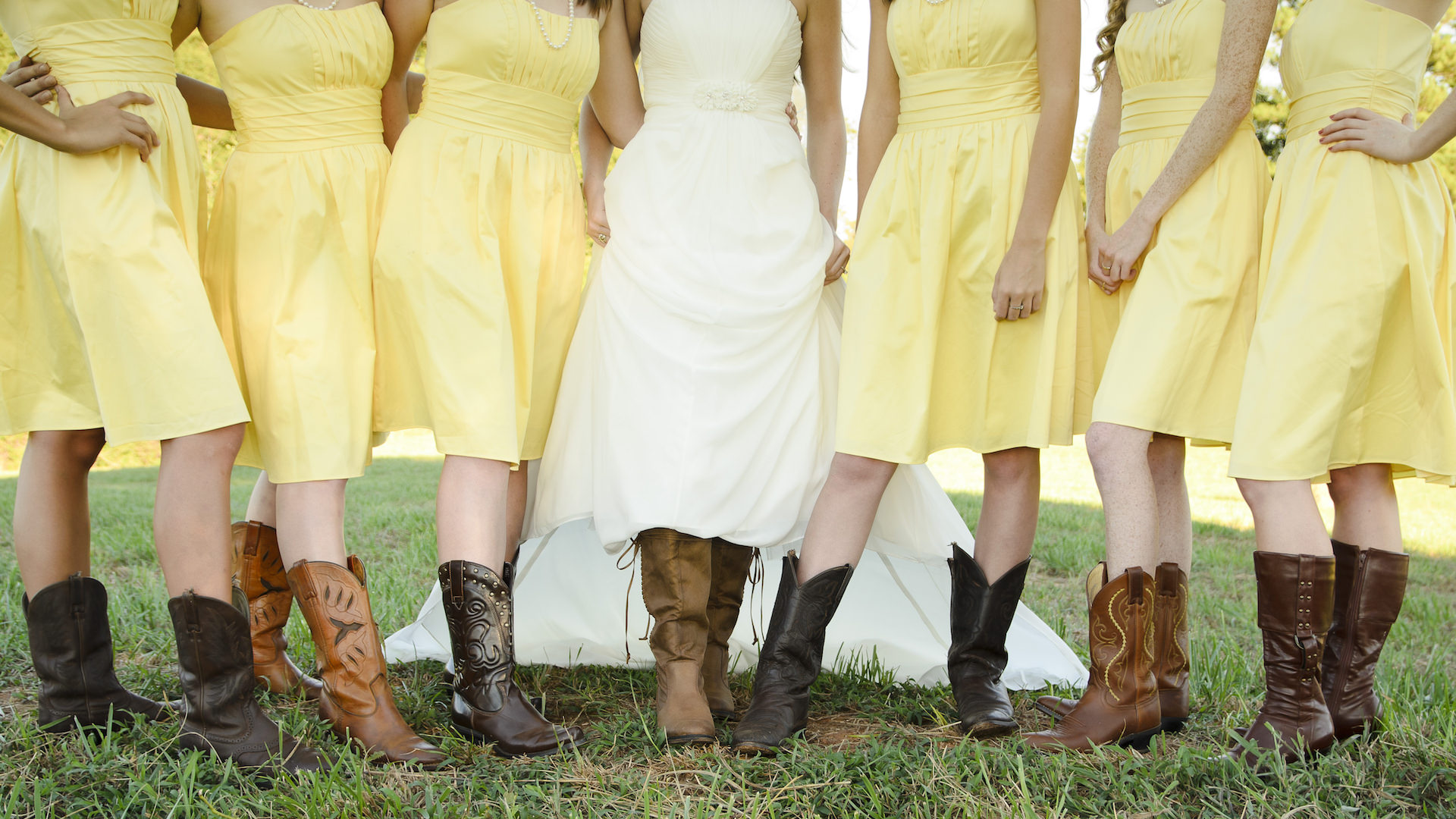 Bride and Bridesmaids show off their boots at a country wedding.